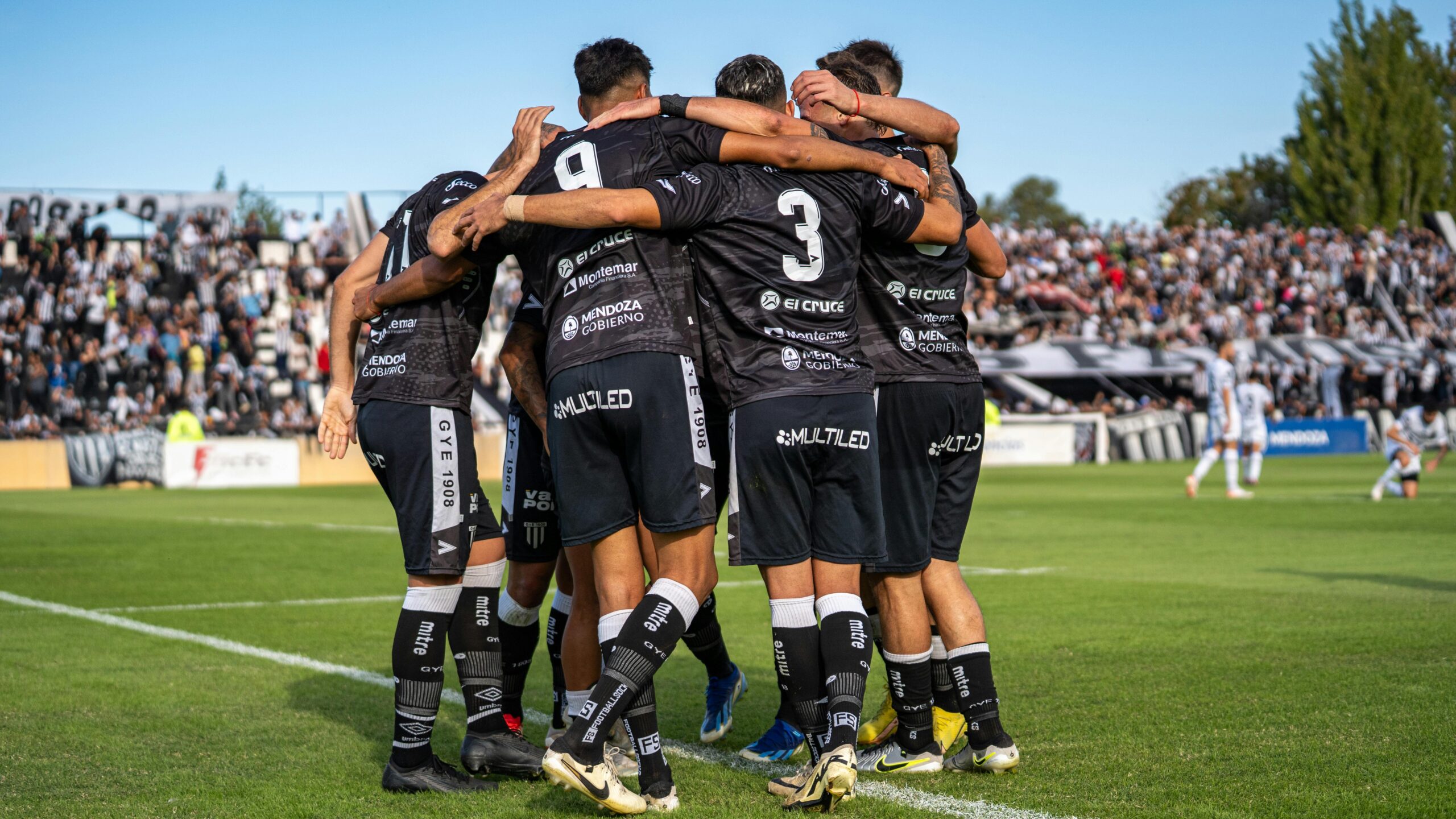 Soccer players celebrating a goal during a match in a vibrant stadium atmosphere.