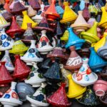 Vibrant artisanal tagine pots on display in Marrakesh market showcase Moroccan craftsmanship.
